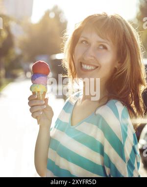Lächelnde Frau, die draußen Eisbecher in den Händen hält Stockfoto