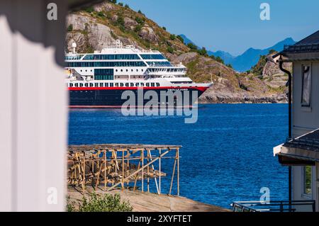 Reine, Norwegen. August 2024. Ein Schiff der Hurtigruten-Reederei Trollfjord verlässt die Stadt reine auf dem Lofoten-Archipel in Nordnorwegen im Norwegischen Meer. Quelle: Patrick Pleul/dpa/Alamy Live News Stockfoto