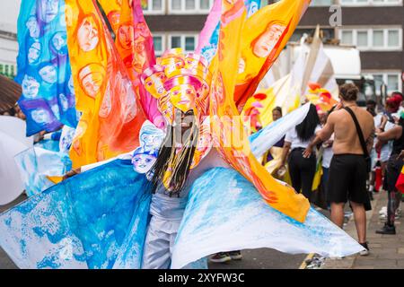 Showtime beim jährlichen Notting Hill Carnival als aufwendig gekleidete Darsteller der Erwachsenenparade schreiten langsam durch West-London Stockfoto