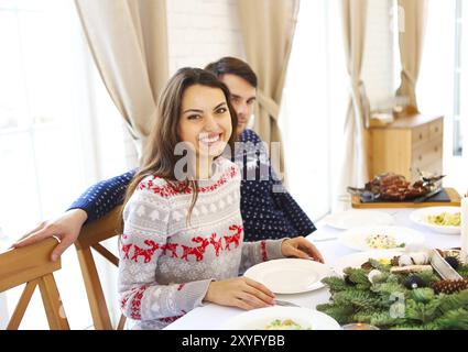 Paar schönen jungen kaukasischen Mann und Frau auf einem Tisch, mit Weihnachtsessen. Weihnachten, Essen, Feier-Konzept Stockfoto