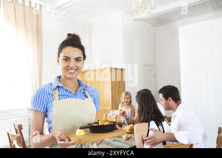 Junge Frau mit Pfanne. Speisenausgabe. Nahaufnahme Stockfoto