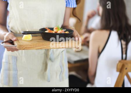 Kellnerin mit Pfanne. Speisenausgabe. Nahaufnahme Stockfoto