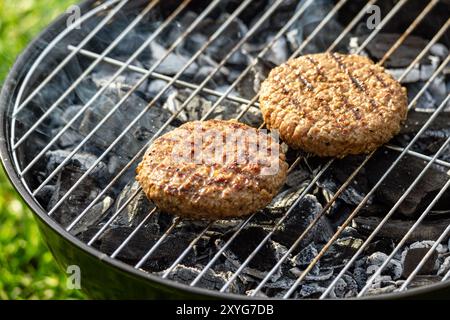 Gegrillte Burger-Fleischpasteten auf brennendem Holzkohlegrill Stockfoto