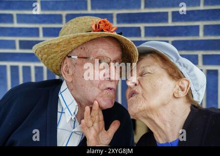 Frontales Nahporträt eines zärtlichen Seniorenpaares, das sich auf der Terrasse küsst. Stockfoto