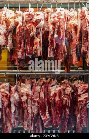 Fleischstücke, die in einem Schaufenster eines Metzgers zum Verkauf gehängt werden. Stockfoto