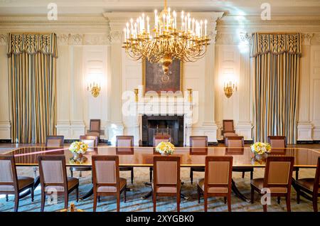 White House State Dining Room Washington DC // WASHINGTON DC – der State Dining Room im Weißen Haus, ein großer Raum, der für offizielle Staatsessen und diplomatische Empfänge genutzt wird. Dieses historische Zimmer ist elegant eingerichtet, darunter ein großer Kamin und ein prominentes Porträt von Abraham Lincoln. Der State Dining Room bietet Platz für bis zu 140 Gäste bei formellen Abendessen mit Sitzplätzen. Stockfoto