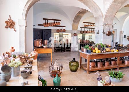 SINTRA, Portugal – die große Küche im Pena Palace mit einer beeindruckenden Auswahl an Kupferkochtöpfen und Kochmöglichkeiten aus dem 19. Jahrhundert. Dieser gut erhaltene Raum bietet Besuchern einen Einblick in die kulinarischen Aktivitäten eines königlichen Haushalts mit seinem weitläufigen Herd, den kunstvollen Fliesen und den glänzenden Utensilien, die den opulenten Charakter des Palastes und die fortschrittlichen Kochtechnologien der Zeit widerspiegeln. Stockfoto