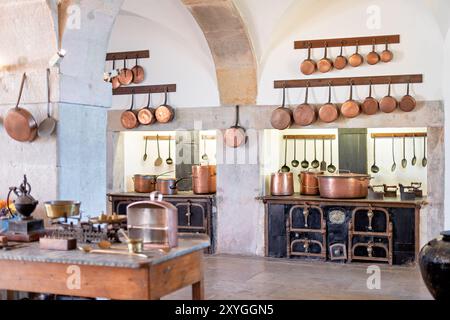 SINTRA, Portugal – die große Küche im Pena Palace mit einer beeindruckenden Auswahl an Kupferkochtöpfen und Kochmöglichkeiten aus dem 19. Jahrhundert. Dieser gut erhaltene Raum bietet Besuchern einen Einblick in die kulinarischen Aktivitäten eines königlichen Haushalts mit seinem weitläufigen Herd, den kunstvollen Fliesen und den glänzenden Utensilien, die den opulenten Charakter des Palastes und die fortschrittlichen Kochtechnologien der Zeit widerspiegeln. Stockfoto