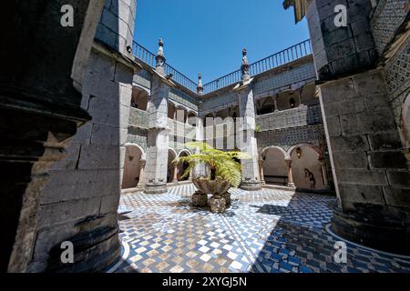 SINTRA, Portugal — das Kloster Manuelinie im Pena Palace, das ursprünglich 1511 erbaut wurde, verfügt über zwei Etagen mit Wänden, die mit hispano-maurischen Fliesen aus dem 16. Jahrhundert verziert sind. Bei der Umwandlung des Klosters in einen königlichen Palast wurden die Bögen des Kreuzgangs mit Fenstern verschlossen, die später in den 1930er Jahren entfernt wurden Die Klostergalerien, einst Teil des Klosters, dienen heute als Korridore im Palast. Stockfoto