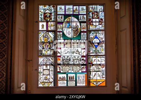 Pena Palace 19. Jahrhundert kunstvoller Innenraum Buntglasfenster Sintra Portugal | SINTRA, Portugal — Ein kunstvolles Buntglasfenster ist in das reich geschmückte Innere des Pena Palace eingebaut und ergänzt die aufwendig gestalteten Wandflächen und die zeitgenössischen Einrichtungsgegenstände, die die romantischen Räume des Gebäudes prägen. Das Schloss wurde zwischen etwa 1842 und 1854 unter der Leitung von Baron Wilhelm Ludwig von Eschwege erbaut und verwirklichte die künstlerische Vision von König Ferdinand II — dem in Deutschland geborenen „Künstler-König“ — in einer theatralischen Zusammenstellung von Neo-Manueliner, Neo-Maurischen, Neo-Gotischen und Neo-Renaissance-Formen. St Stockfoto