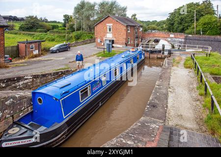 Schmalboot, das durch die Doppeltreppenschleusen am Shropshire Union Canal bei Bunbury Cheshire fährt Stockfoto