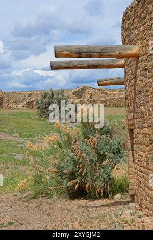 Aus restaurierten Steinmauermauern ragen Holz-Viga-Balken vor den antiken Ruinen des Aztec Ruins National Monument hervor Stockfoto