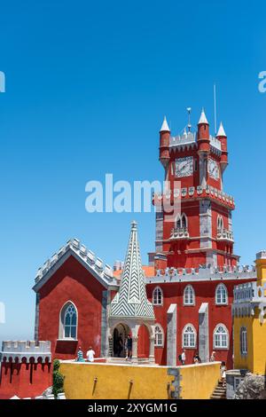 SINTRA, Portugal – der prunkvolle rote Turmglockenturm des Pena Palace hebt sich vom Himmel ab und zeigt die lebhaften Farben und die eklektische romantische Architektur dieser königlichen Residenz aus dem 19. Jahrhundert. Diese Besonderheit verkörpert den märchenhaften Charme, der Pena Palace zu einem Wahrzeichen in Sintra macht. Stockfoto