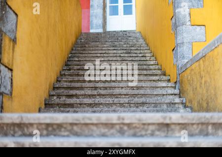 SINTRA, Portugal – Eine Steintreppe am Pena-Palast, ein prominentes architektonisches Wahrzeichen in Sintra, Portugal. Der Palast ist berühmt für seine romantische Architektur und gehört zum UNESCO-Weltkulturerbe. Die Treppe ist eine von vielen, die Besucher durch das weitläufige Palastgelände führen, das gotische, maurische und Renaissance-architektonische Einflüsse vereint. Stockfoto