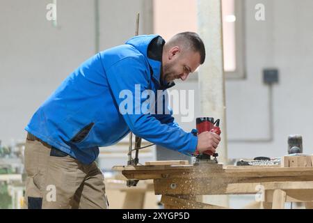 Nahaufnahme des Arbeiters sorgfältig schneiden und Hobeln von Holzstücken für Möbel in der Holzindustrie Stockfoto