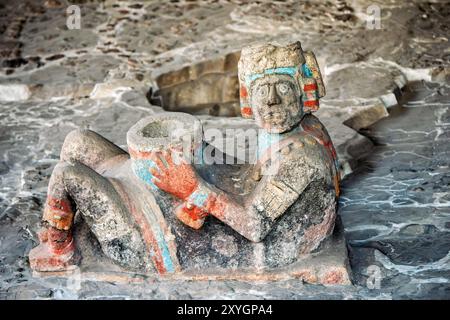 MEXIKO-STADT, Mexiko – Eine bunt gemalte chac Mool-Skulptur, die Tlaloc, den aztekischen Regengott, darstellt, der am Ort des Bürgermeisters von Templo gefunden wurde. Dieses gut erhaltene Artefakt mit seinen lebendigen polychromen Details bietet Besuchern einen seltenen Einblick in die künstlerischen und religiösen Praktiken der aztekischen Zivilisation. Stockfoto