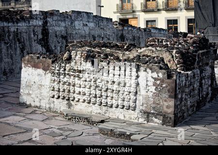 MEXIKO-STADT, Mexiko – der Altar Tzompantli (Gebäude B) am Ort des Bürgermeisters von Templo mit Reihen von aufwändig geschnitzten Steinschädeln. Diese Struktur, verbunden mit aztekischen Opferpraktiken, bietet einen eindrucksvollen Einblick in die religiösen und kosmologischen Überzeugungen der präkolumbianischen mesoamerikanischen Kultur. Stockfoto