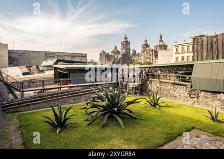 MEXIKO-STADT, Mexiko – die Metropolitano Sagrario und Catedral Metropolitana in der Ferne, von den ausgegrabenen Ruinen des Bürgermeisters von Templo aus gesehen. Diese eindrucksvolle Gegenüberstellung zeigt die geschichtsträchtige Geschichte von Mexiko City, mit katholischen Strukturen aus der Kolonialzeit, die über den Überresten des Haupttempels des Aztekenreichs ragen. Stockfoto