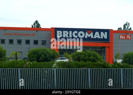 Nizza, Frankreich - 6. Juni 2023: Große Ladenfront mit Bricoman-Schild, umgeben von Büschen und Metallzaun. Das Gebäude hat orangefarbene Akzente und große Fenster. Whit Stockfoto