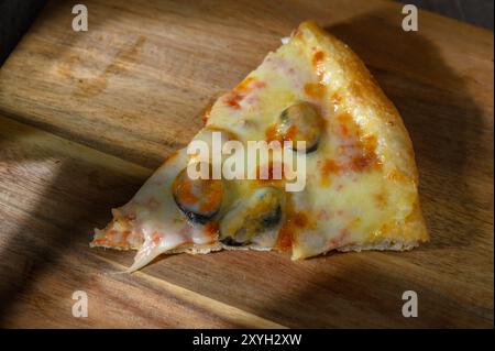 italienische Pizza mit Meeresfrüchten in Scheiben mit Garnelen, Tintenfischen, Muscheln, Muscheln und Tintenfischen Stockfoto