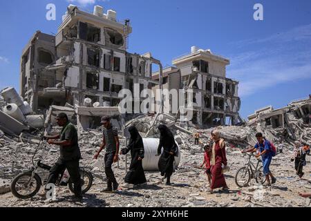 Gaza. August 2024. Vertriebene kehren am 29. August 2024 in der Stadt Deir al-Balah im zentralen Gazastreifen zurück. Am Donnerstag sagte das UN-Büro für die Koordinierung humanitärer Angelegenheiten (OCHA), dass die israelischen Behörden angekündigt haben, dass Vertriebene in bestimmte Gebiete in Deir al-Balah zurückkehren könnten, das erste Mal, dass die Rückkehr in ein evakuiertes Gebiet offiziell erlaubt ist. Quelle: Rizek Abdeljawad/Xinhua/Alamy Live News Stockfoto