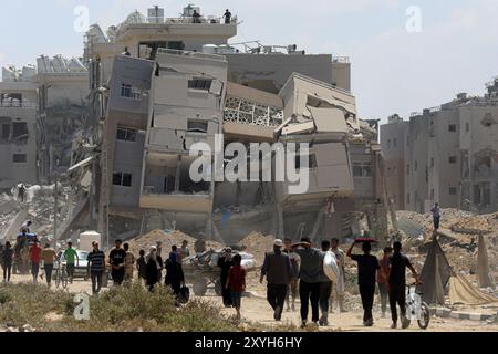 Gaza. August 2024. Vertriebene kehren am 29. August 2024 in der Stadt Deir al-Balah im zentralen Gazastreifen zurück. Am Donnerstag sagte das UN-Büro für die Koordinierung humanitärer Angelegenheiten (OCHA), dass die israelischen Behörden angekündigt haben, dass Vertriebene in bestimmte Gebiete in Deir al-Balah zurückkehren könnten, das erste Mal, dass die Rückkehr in ein evakuiertes Gebiet offiziell erlaubt ist. Quelle: Rizek Abdeljawad/Xinhua/Alamy Live News Stockfoto