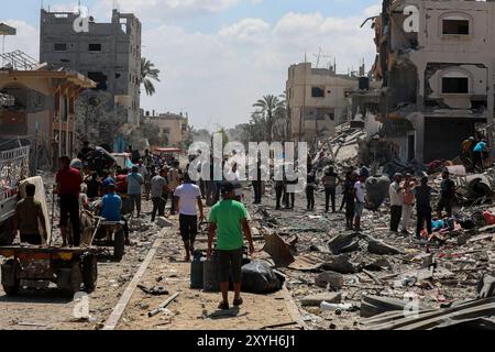 Gaza. August 2024. Vertriebene kehren am 29. August 2024 in der Stadt Deir al-Balah im zentralen Gazastreifen zurück. Am Donnerstag sagte das UN-Büro für die Koordinierung humanitärer Angelegenheiten (OCHA), dass die israelischen Behörden angekündigt haben, dass Vertriebene in bestimmte Gebiete in Deir al-Balah zurückkehren könnten, das erste Mal, dass die Rückkehr in ein evakuiertes Gebiet offiziell erlaubt ist. Quelle: Rizek Abdeljawad/Xinhua/Alamy Live News Stockfoto