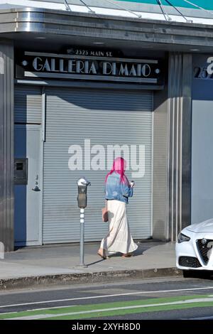 Frau mit rosa Haaren, die auf der Main Street in Santa Monica, Kalifornien, USA läuft Stockfoto