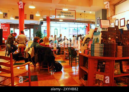 Asheville, NC, USA 23. April 2012 Freunde genießen eine entspannte Zeit, sitzen und unterhalten sich in einem Käfig in einem Buchladen in Asheville, North Carolina Stockfoto