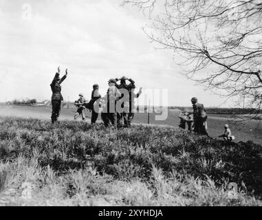 US-Soldaten fangen SS-Männer auf der Flucht aus Dachau ein. Dachau war das erste Konzentrationslager der nazis, das am 22. März 1933 eröffnet wurde (nur sieben Wochen nach der Machtergreifung Hitlers). Obwohl es ein Zwangsarbeitslager war und es dort keine Gaskammern gab, waren Brutalität und gewalttätige Strafen die Norm. Dort gab es 32000 dokumentierte Todesfälle und viele Tausende weitere undokumentierte Todesfälle. Das Hauptlager (Dachau hatte 100 Unterlager) wurde am 29. April 1945 von der US-Armee befreit. Stockfoto