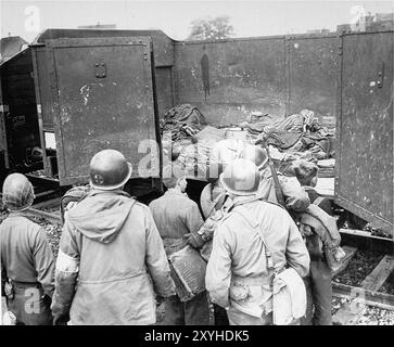 Der Todeszug Dachau bestand aus fast vierzig Triebwagen mit 5000 Gefangenen, die am 7. April 1945 aus Buchenwald evakuiert wurden. Der Zug kam am Nachmittag des 28. April mit den Leichen von 2.000 bis 3.000 Gefangenen in Dachau an, die während der Reise ums Leben gekommen waren. Der Zug mit den Leichen wurde von der US-Armee gefunden, als er am nächsten Tag freigelassen wurde. Obwohl es ein Zwangsarbeitslager war und es dort keine Gaskammern gab, waren Brutalität und gewalttätige Strafen die Norm. Hier zwingen US-Soldaten Mitglieder der Hitlerjugend, sich die entsetzliche Szene anzusehen. Stockfoto