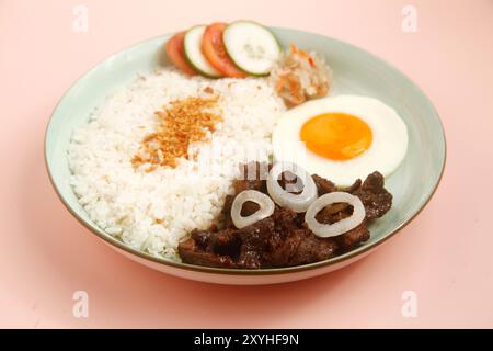 Foto von frisch gekochten philippinischen Speisen namens TapSilog oder Rindfleisch-Tender serviert mit gebratenem Reis und Ei. Stockfoto