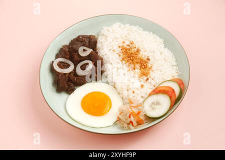 Foto von frisch gekochten philippinischen Speisen namens TapSilog oder Rindfleisch-Tender serviert mit gebratenem Reis und Ei. Stockfoto