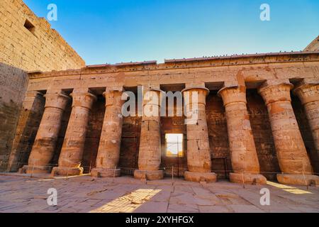 Imposante Kolonnaden mit Reliefs am ersten Hof im herrlichen Tempel von Medinet Habu - Totentempel von Ramesses III. Erbaut um 1170 v. Chr. in Luxor, Ägypten Stockfoto