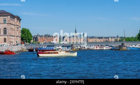 Stockholms ström (Stockholms Stream) mit Skeppsholmsbron (Skeppsholmsbron) und Booten, Stockholms Uferpromenade, Schweden, sonniger Tag mit Blick auf die Stadt. Stockfoto