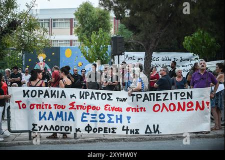 Athen, Griechenland. August 2024. Demonstranten halten ein Banner mit der Aufschrift „die Heimat von Spyros ist die Heimat von jedem von uns. Keine Zwangsvollstreckung von Wohnungen“ während eines Protestes gegen eine Vertreibung der Familie aus ihrem Haus aufgrund von Zwangsvollstreckungen von Immobilien. Die Demonstranten beschuldigen die Banken, die Gelder und die griechische Regierung für Grausamkeit, da sie behaupten, dass die Familie, die ihre Hypothek nicht zurückzahlen kann, ein behindertes Kind habe. Das Land steht vor einem sich verschärfenden Wohnungsmangel, der zu einem ernsten sozialen Problem geworden ist und für normale Haushalte äußerst unerschwinglich ist. Quelle: Dimitris Aspiotis/Alamy Live News Stockfoto