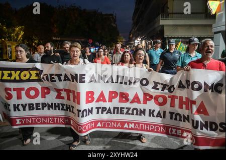 Athen, Griechenland. August 2024. Demonstranten marschieren mit einem Banner mit der Aufschrift „stoppt die Grausamkeit der Regierung der Banken und der Fonds“ während eines Protests gegen eine Vertreibung der Familie aus ihrem Haus aufgrund von Zwangsvollstreckungen. Die Demonstranten beschuldigen die Banken, die Gelder und die griechische Regierung für Grausamkeit, da sie behaupten, dass die Familie, die ihre Hypothek nicht zurückzahlen kann, ein behindertes Kind habe. Das Land steht vor einem sich verschärfenden Wohnungsmangel, der zu einem ernsten sozialen Problem geworden ist und für normale Haushalte äußerst unerschwinglich ist. Quelle: Dimitris Aspiotis/Alamy Live News Stockfoto