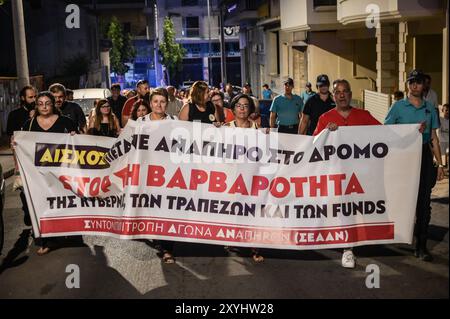 Athen, Griechenland. August 2024. Demonstranten marschieren mit einem Banner mit der Aufschrift „stoppt die Grausamkeit der Regierung der Banken und der Fonds“ während eines Protests gegen eine Vertreibung der Familie aus ihrem Haus aufgrund von Zwangsvollstreckungen. Die Demonstranten beschuldigen die Banken, die Gelder und die griechische Regierung für Grausamkeit, da sie behaupten, dass die Familie, die ihre Hypothek nicht zurückzahlen kann, ein behindertes Kind habe. Das Land steht vor einem sich verschärfenden Wohnungsmangel, der zu einem ernsten sozialen Problem geworden ist und für normale Haushalte äußerst unerschwinglich ist. Quelle: Dimitris Aspiotis/Alamy Live News Stockfoto