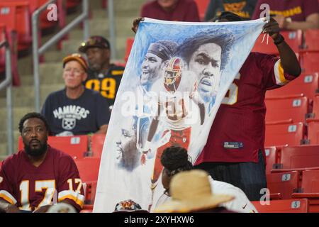 Der Fan der Washington Commanders hält ein Wandbild des ehemaligen Spielers Sean Taylor vor dem NFL-Vorsaisonspiel zwischen den New England Patriots in Washington Comm Stockfoto
