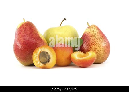 Ganze und halbierte reife Aprikosen, mehrfarbige Birnen und grüner Apfel, isoliert auf weißem Hintergrund. Multivitamin und saftige Früchte Stockfoto