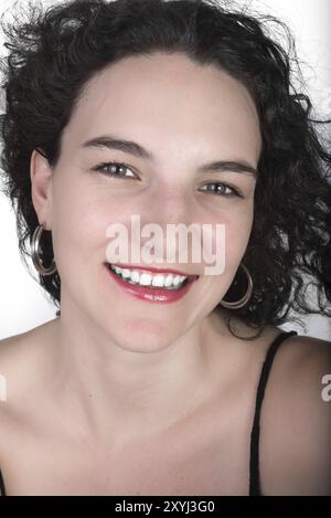 Ein junges Model Mitte 20 in einem schwarzen offenen Schultertop mit einem großen Lächeln Stockfoto