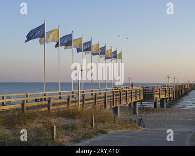 Ein langer Holzsteg mit winkenden Fahnen und Laternen in der Abenddämmerung, binz, rügen, ostsee, deutschland Stockfoto