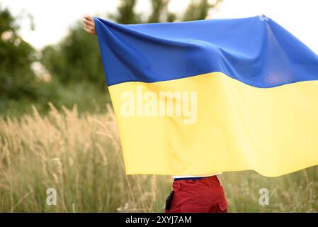 Ukraines Unabhängigkeit Flag Day. Tag der Verfassung. Ukrainischer Junge im Hemd mit gelber und blauer Flagge der Ukraine im Feld. Flaggensymbole der Ukraine. Kiew, Kiewer Tag Stockfoto