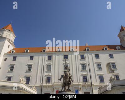 Majestätischer Blick auf eine barocke Burg mit einer Reiterstatue im Vordergrund und blauem Himmel, Bratislava, Slowakei, Europa Stockfoto