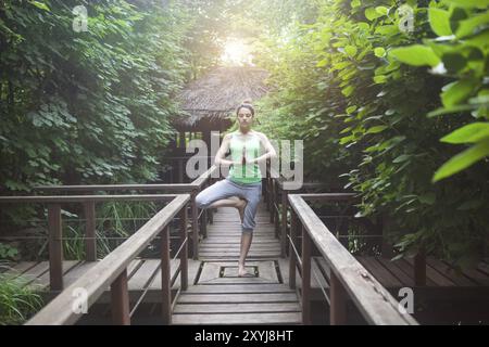 Junge Frau tut Yoga Asana am Abend im freien Stockfoto