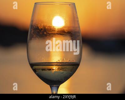 Sonnenuntergang schimmert durch ein Glas Weißwein, Abendstimmung im Hafen, Murter Hafen, Murter Insel, Kroatien, Europa Stockfoto