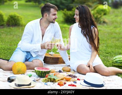 Junges Paar in Liebe auf Sommer Picknick Toasten mit Weißwein Stockfoto