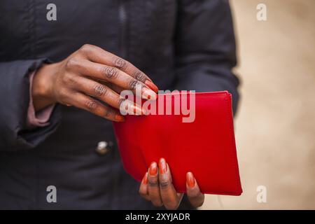 Die Frau hält die rote Brieftasche in der Hand Stockfoto