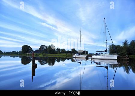 Zwei Yachten auf dem Fluss an einem ruhigen Morgen mit schöner Wolkenlandschaft Stockfoto