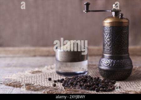 Schwarze Pfefferkörner und schwarzer Pfeffer Pulver auf hölzernen Hintergrund Stockfoto